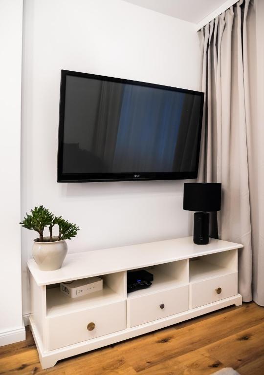 Televízia a/alebo spoločenská miestnosť v ubytovaní Fort Wola Golden Apartment