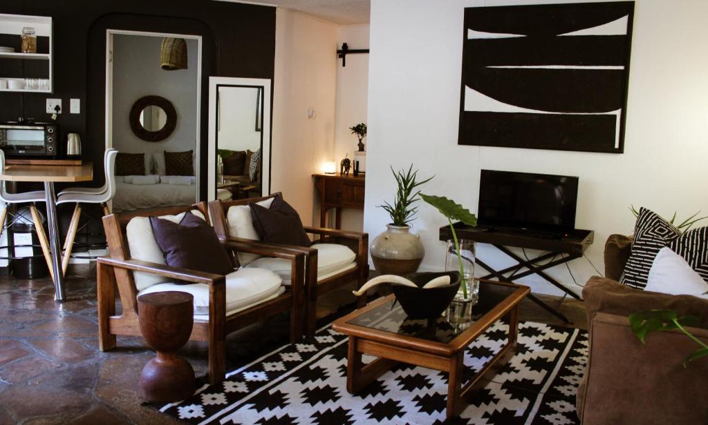 sala de estar con sofás y mesa en ALLURING SELF CATERING 2 BEDROOM VILLA at BOKMAKIERIE VILLAS en Windhoek