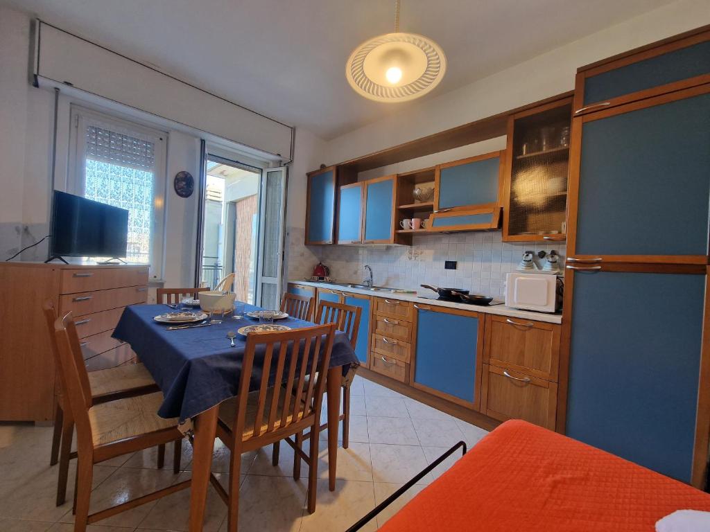 a kitchen with a table and chairs and a kitchen with blue cabinets at [Loano Centro] Vista aperta nel cuore del Paese in Loano