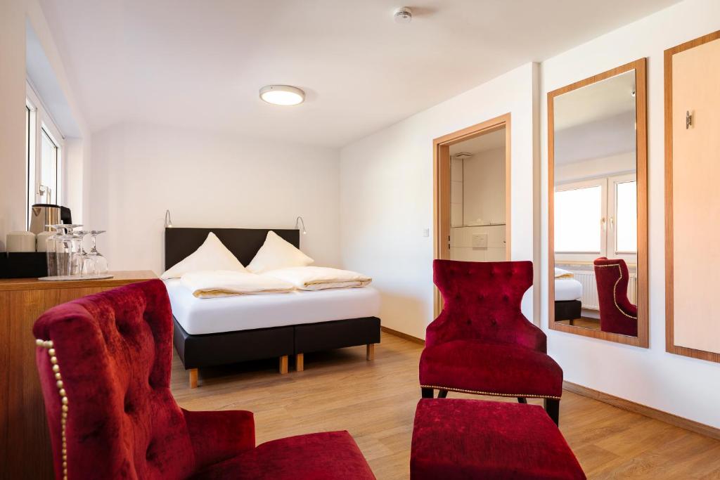 a bedroom with a bed and a red chair at Helgolandia Dependance in Helgoland