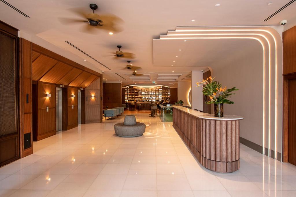 A contemporary lobby reception area with wood-panelled lifts and a curved desk.