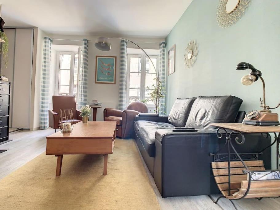 un salon avec un canapé bleu et une table dans l'établissement Location Granville - Remparts de la Hauteville, à Granville