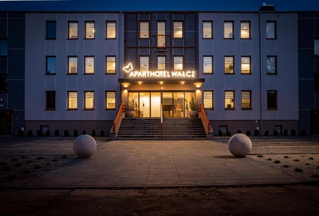 a building with a sign on the front of it at APARTHOTEL Wałcz in Wałcz