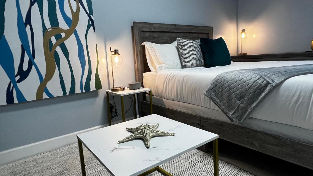 1 dormitorio con 1 cama y 1 estrella de mar sobre una mesa en Oceano Suites Daytona Beach, en Daytona Beach