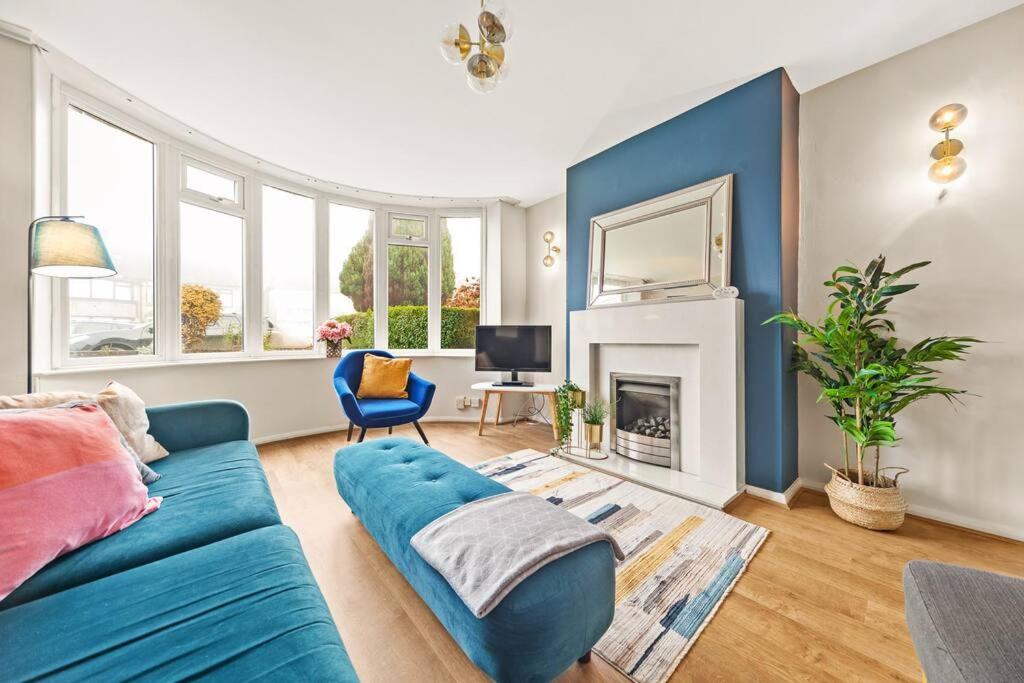 - un salon avec un canapé bleu et une cheminée dans l'établissement Spacious 3 bed house in North Leeds perfect for families & longer stays, à Adel