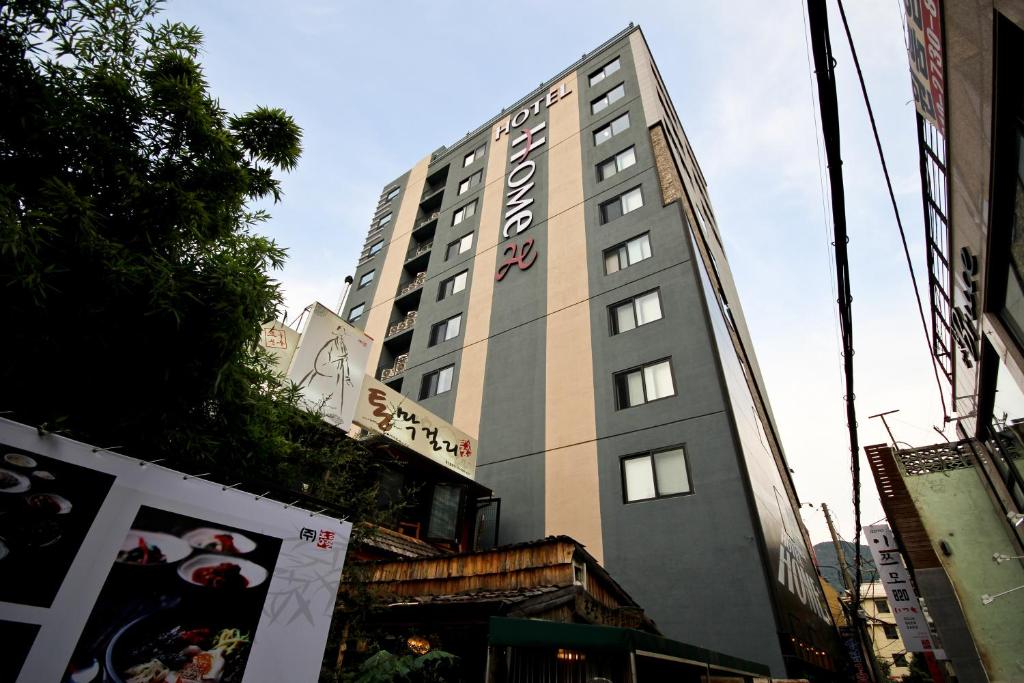 a tall building in the middle of a street at Hotel Home in Busan