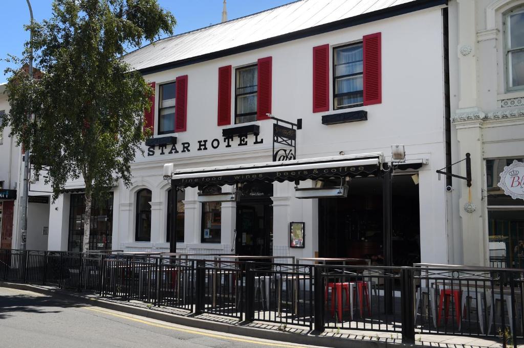 un edificio bianco con persiane rosse su una strada di Star Bar Cafe & Hotel a Launceston