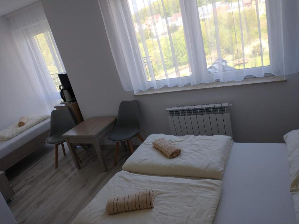 a bedroom with two beds and a desk and windows at Bożenka in Niechorze