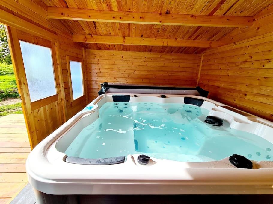 a jacuzzi tub in a wooden house at Gîte le Chalet Aura & jacuzzi in Abreschviller
