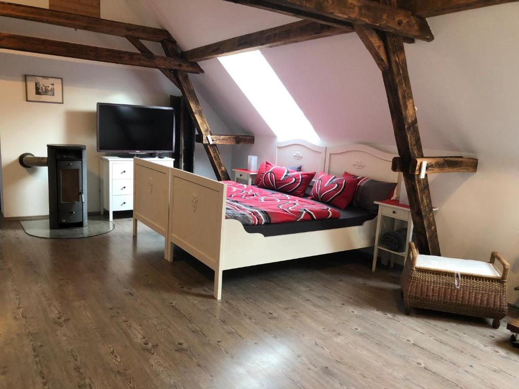a bedroom with a bed and a television in a attic at Apartment Maria in Kürten