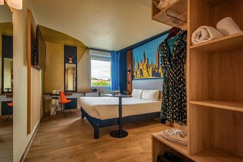 una camera d'albergo con letto e finestra di Ibis Styles Toulouse Blagnac Aéroport a Blagnac