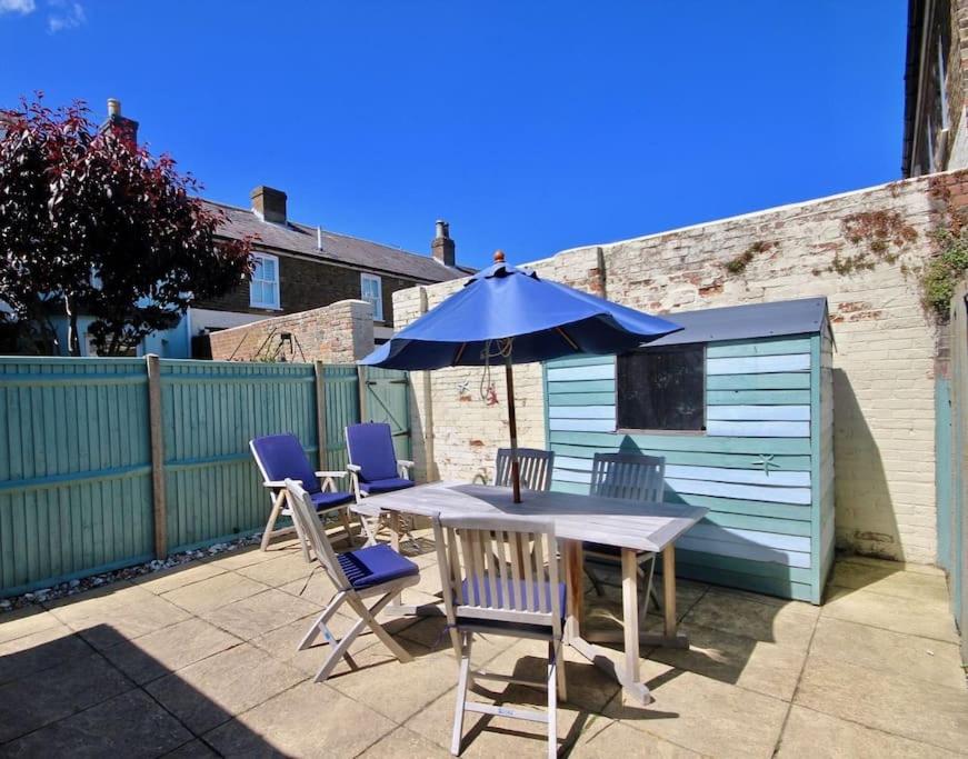 een tafel en stoelen met een parasol op een patio bij Gerald's Place in Deal