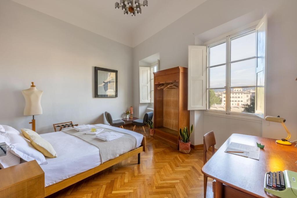 Schlafzimmer mit einem Bett, einem Schreibtisch und einem Tisch in der Unterkunft FuordArno Bed & Breakfast in Florenz