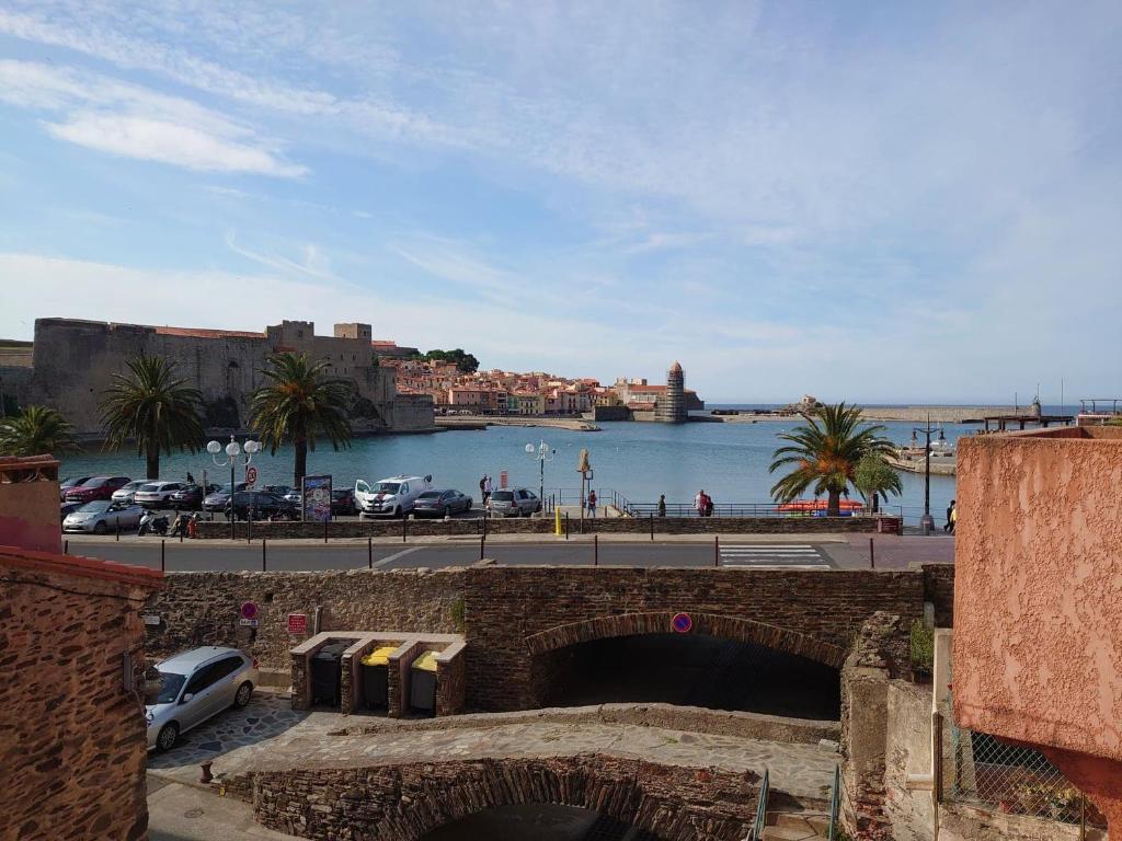 un pont en briques sur une étendue d'eau avec un port dans l'établissement 5COMA4 Appartement vue sur mer, à Collioure