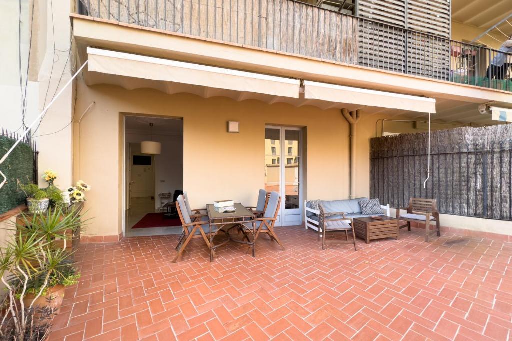 een patio met een tafel en stoelen en een huis bij ApartEasy - Passeig de Gracia in Barcelona