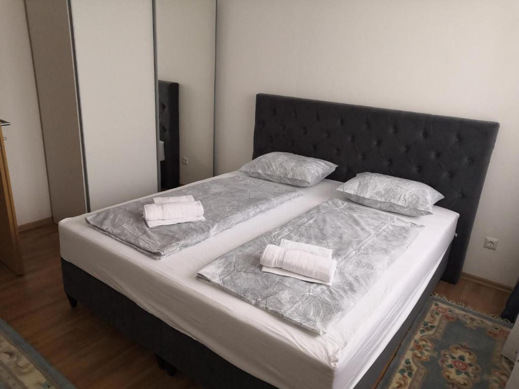 1 cama con cabecero negro y 2 almohadas en Apartman Deni en Travnik