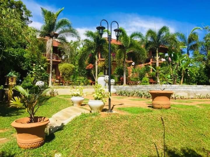un giardino con tre grandi vasi con piante di Eagles Nest Cabanas a Tangalle