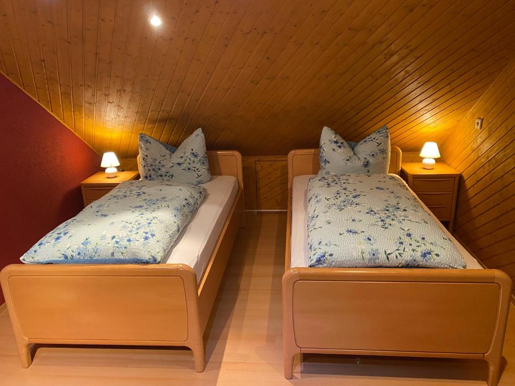 two beds in a small room with two lamps at Haus Zeichner 4 Zimmer Ferienwohnung in Feldberg