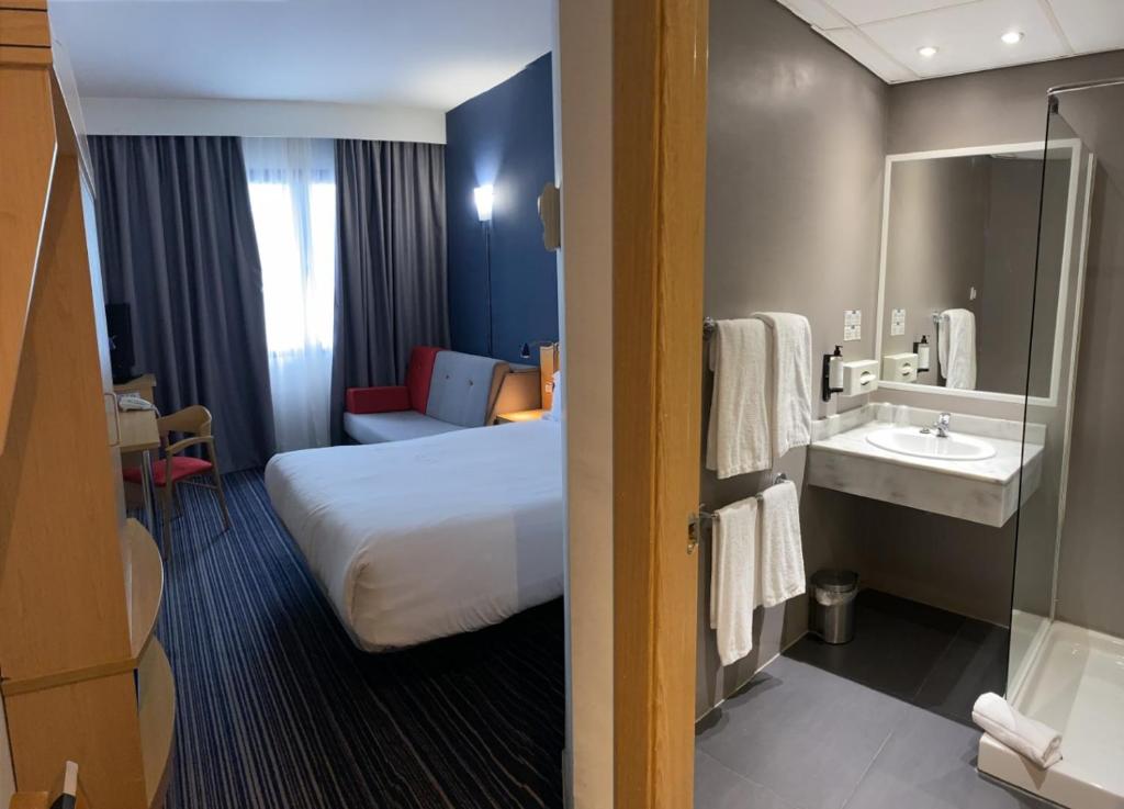 una habitación de hotel con una cama y un lavabo en Holiday Inn Express San Sebastian de los Reyes by IHG, en San Sebastián de los Reyes