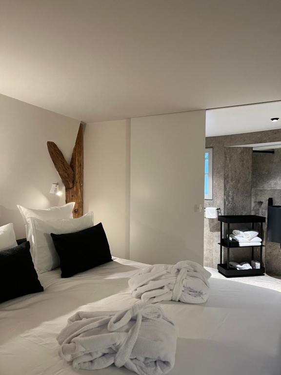 um quarto com uma cama branca e toalhas em O verso du Château - STUDIO 22 em Barr