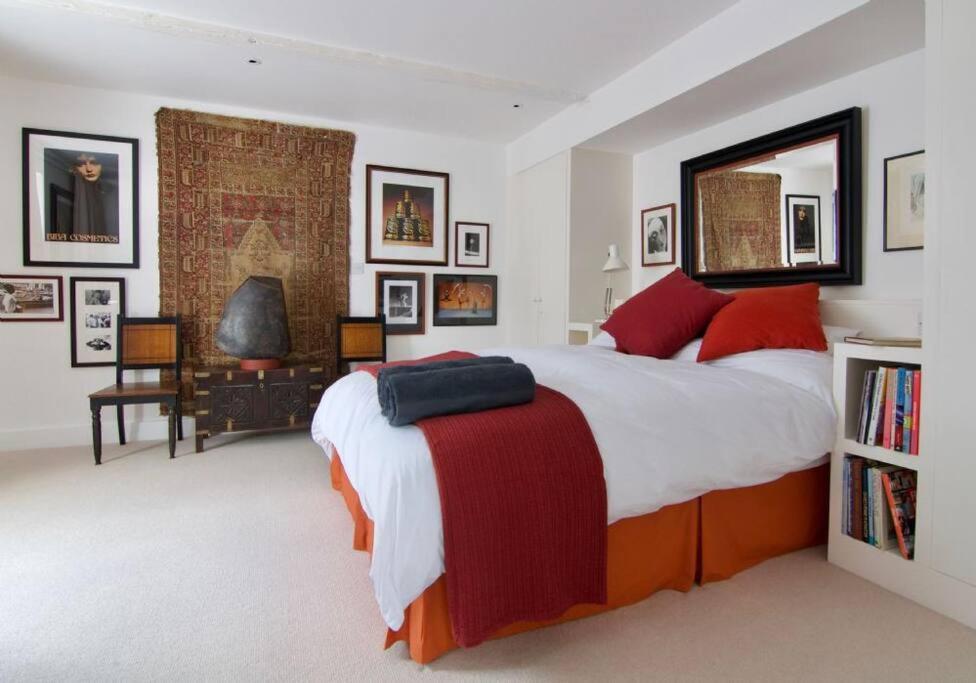 a bedroom with a large bed with red pillows at The Artists House in Deal