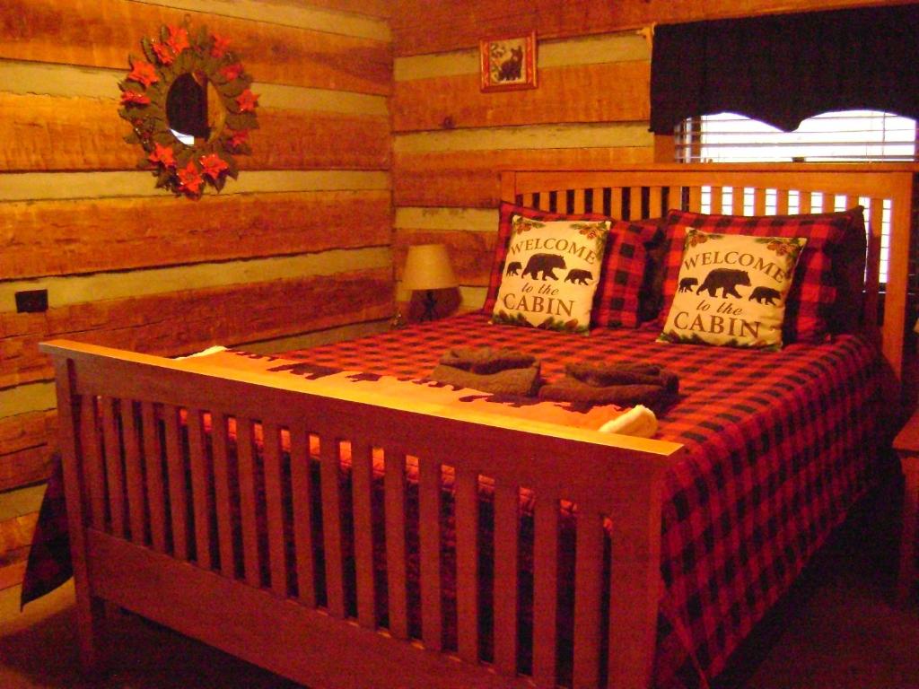 ein Schlafzimmer mit einem Bett in einem Blockhaus in der Unterkunft New Song in Sevierville