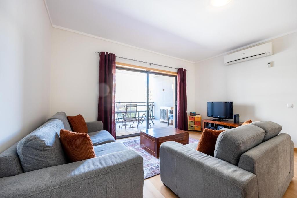 ein Wohnzimmer mit 2 Sofas und einem TV in der Unterkunft Apartment Baixa Marina in Olhão