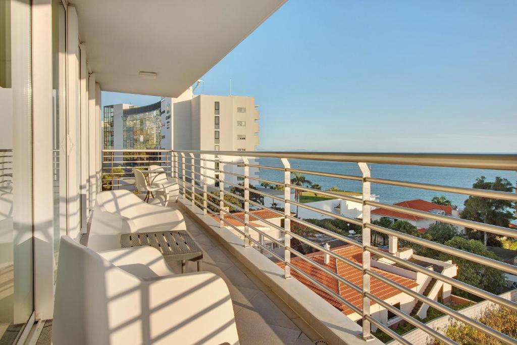 a balcony with white chairs and a view of the ocean at Dfm Happy Days A - Funchal in Funchal