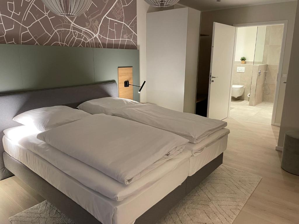 a bedroom with a large white bed in a room at Hotel-Restaurant Haselhoff in Coesfeld