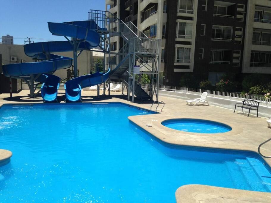 - une grande piscine avec toboggan dans un bâtiment dans l'établissement Departamento en centro de Viña del Mar, à Viña del Mar