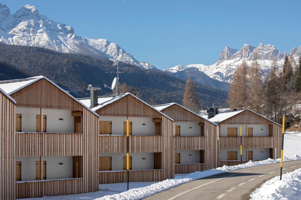 a building with snow covered mountains in the background at Chalet del Capriolo in Vodo Cadore