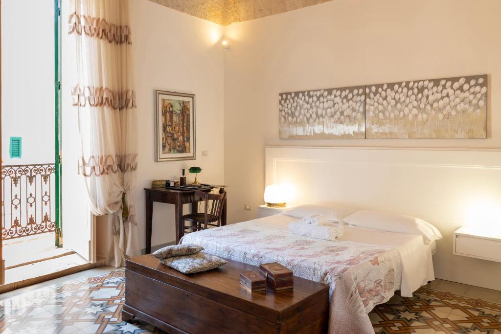 a bedroom with a bed and a table and a window at WePuglia - Catarì in Polignano a Mare