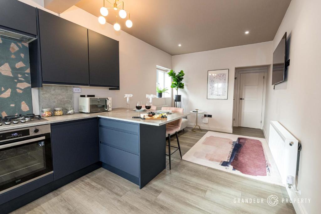 a kitchen with black cabinets and a counter top at New and Modern 1bed, 10 min to beach town parking - To Be Shore in Bournemouth