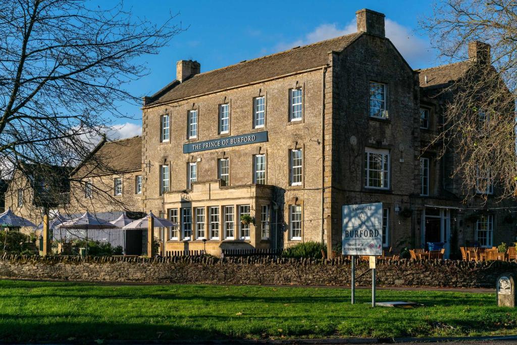 a large brick building with a sign in front of it at Prince of Burford in Burford