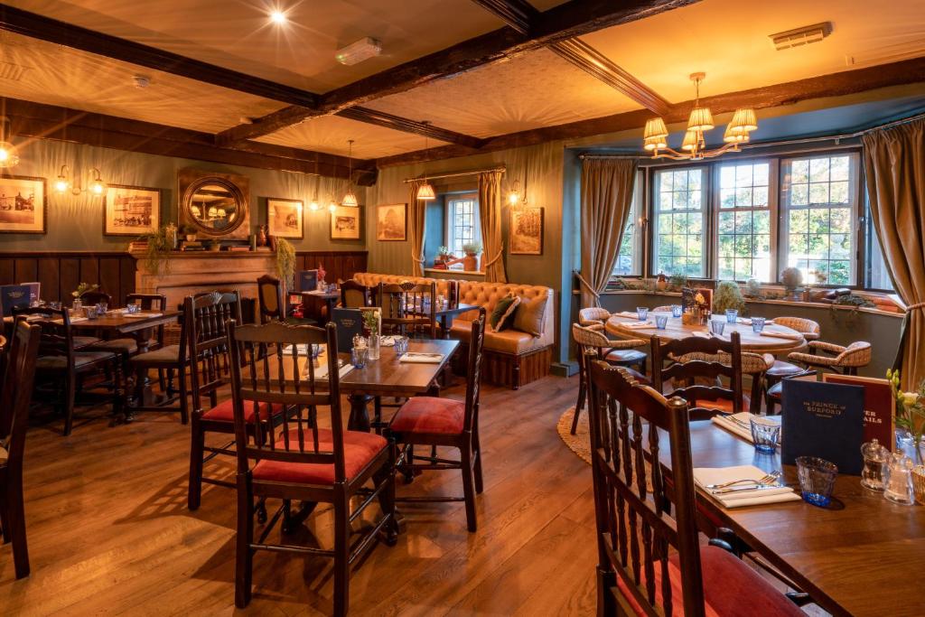 um restaurante com mesas e cadeiras em uma sala em Prince of Burford em Burford