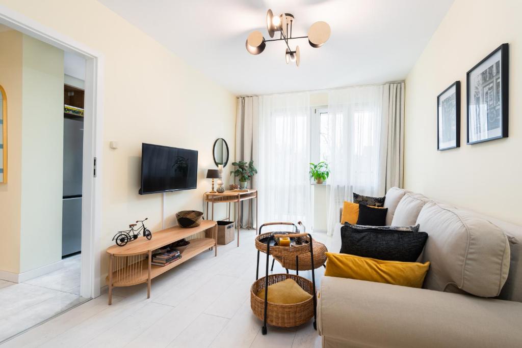 a living room with a couch and a tv at Apartament Chopin - ścisłe centrum - by Kairos Apartments in Gliwice