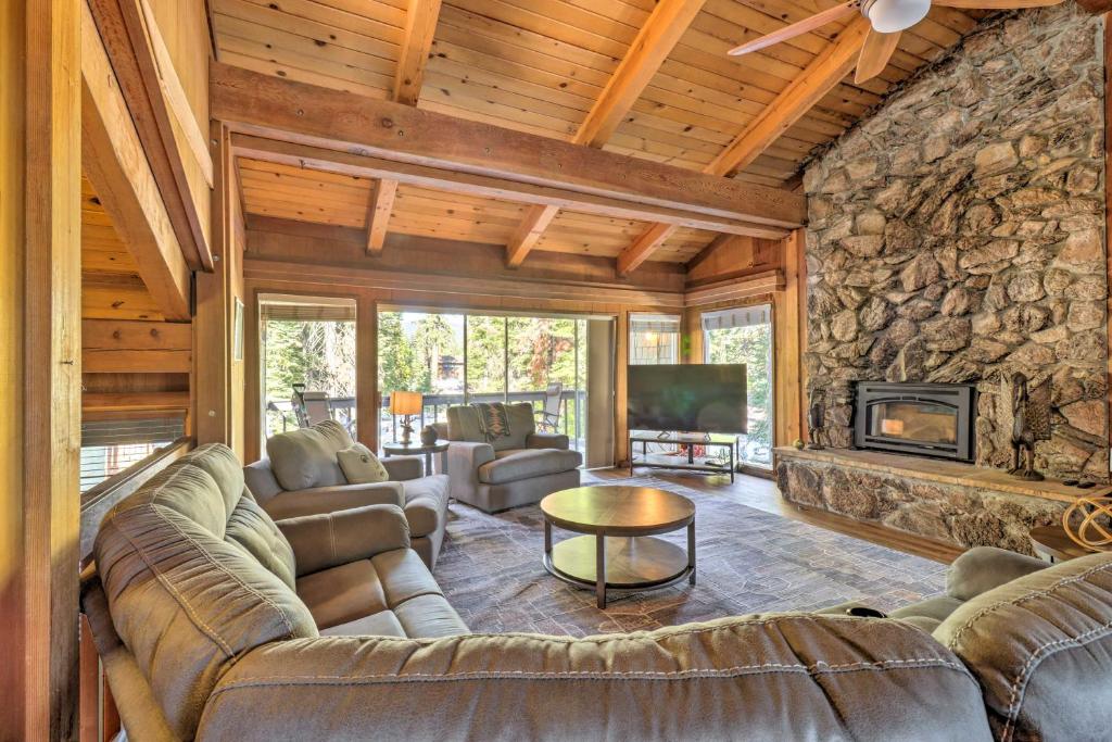 a living room with couches and a stone fireplace at Tahoe City Home with Hot Tub - 1 Mi to Beach in Tahoe City