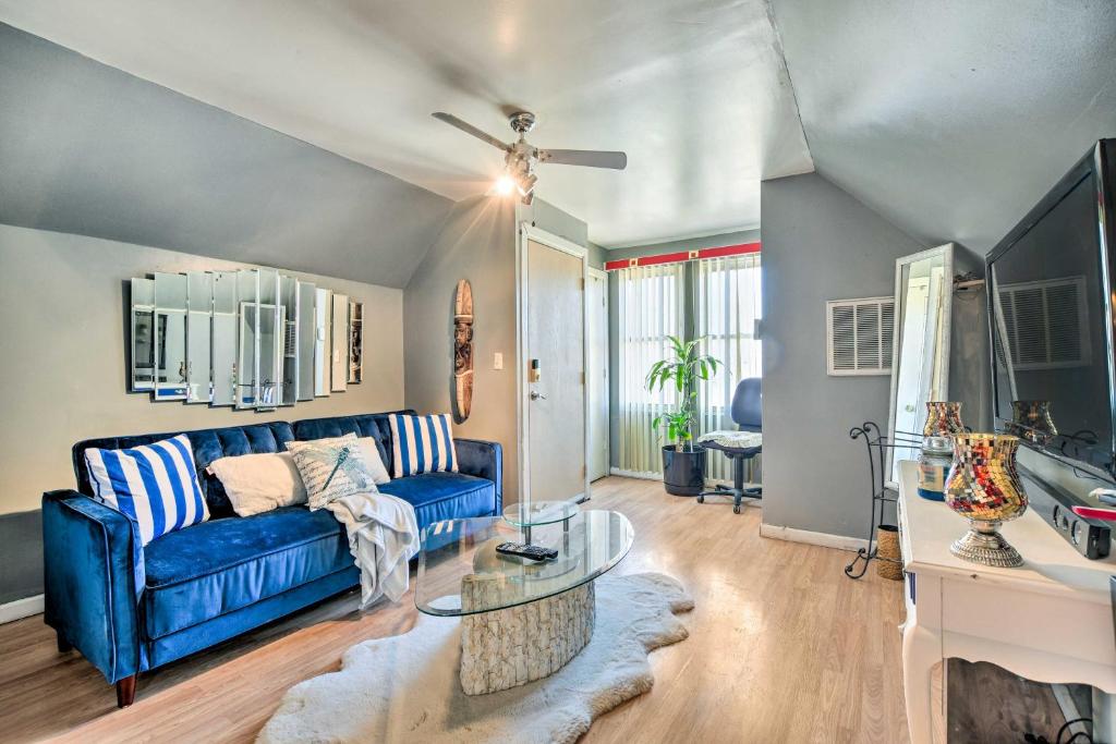 a living room with a blue couch and a table at Eclectic Chicago Apartment with Spacious Deck! in Chicago