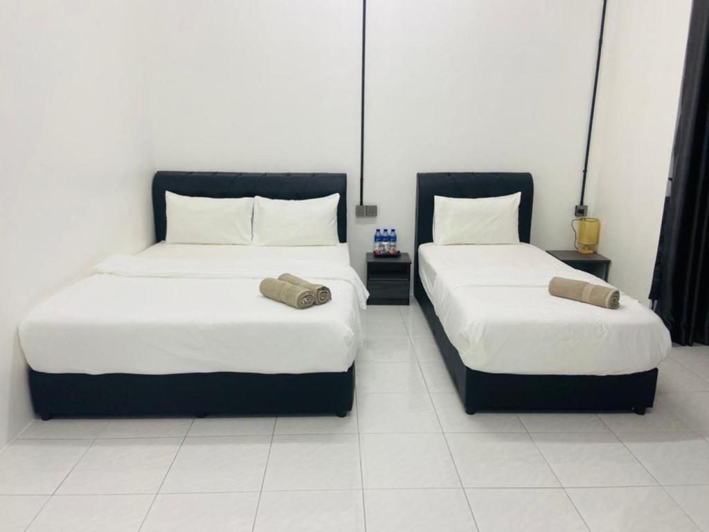 2 letti posti uno accanto all'altro in una stanza di I-STAY 01 JK Roomstay a Kampong Bemban