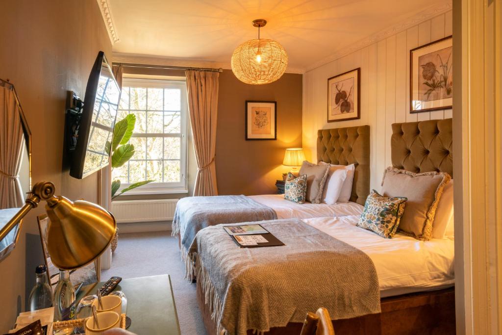 um quarto de hotel com duas camas e uma janela em Prince of Burford em Burford