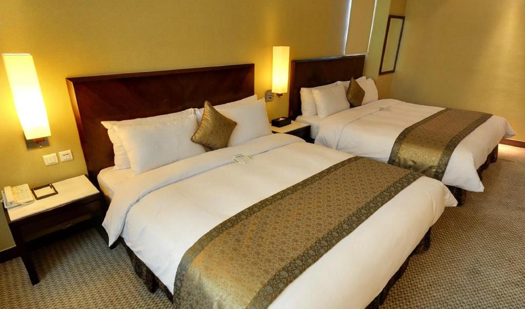 台北的住宿－台北國際飯店，酒店客房设有两张床和两盏灯。