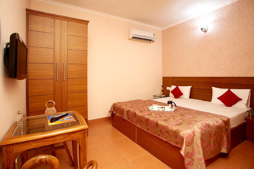 Postel nebo postele na pokoji v ubytování Indira International Inn