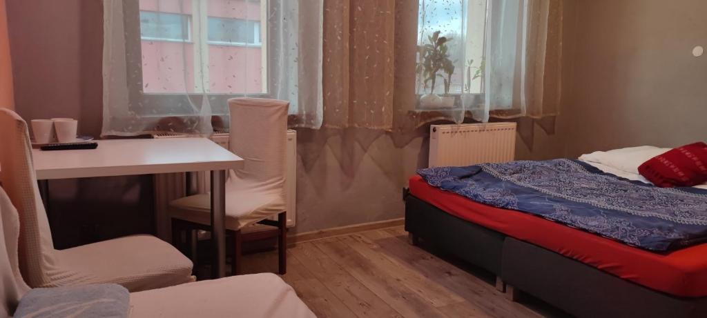 ein kleines Zimmer mit einem Bett, einem Tisch und Stühlen in der Unterkunft Noclegi Centrum in Jelenia Góra