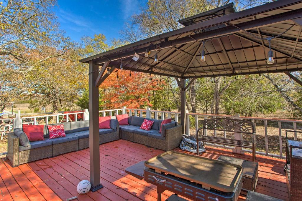 a patio with a couch and an umbrella at Deck, Grill and Yard Pet-Friendly Van Alstyne Gem! in Van Alstyne