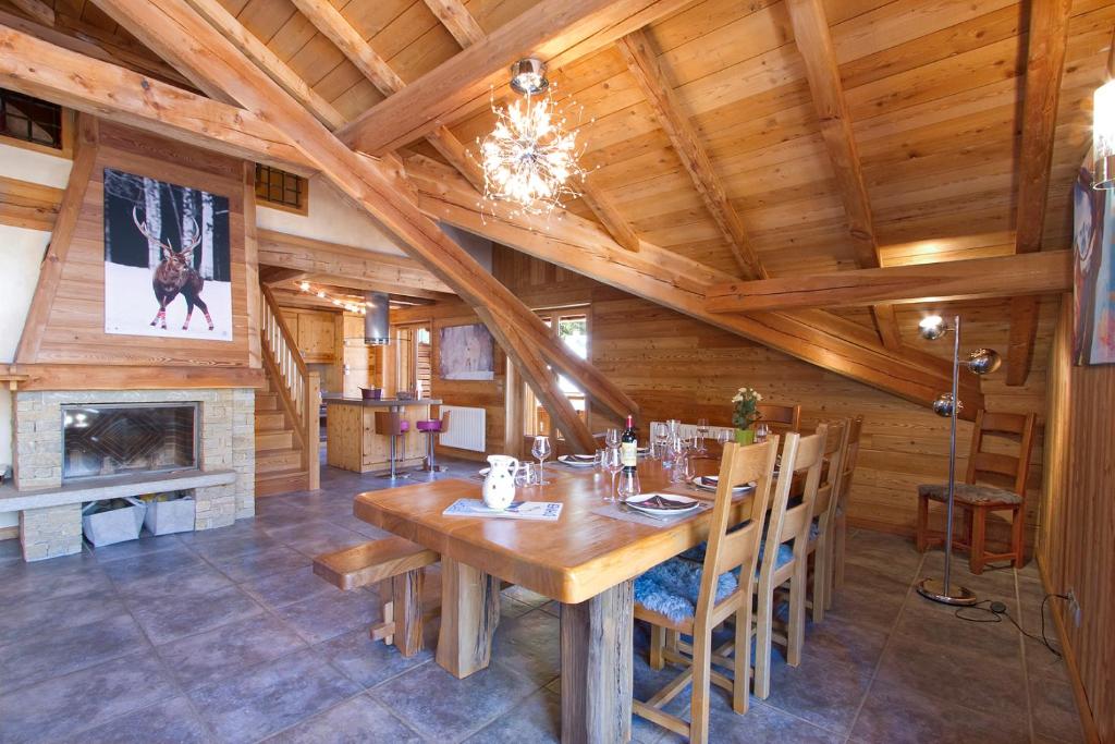 una sala da pranzo con tavolo in legno e camino di Appartement Noel Martin - 3 chambres a Les Deux Alpes