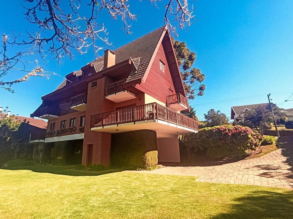 une grande maison avec une grande cour en face dans l'établissement Casa Suiça de Campos, à Campos do Jordão