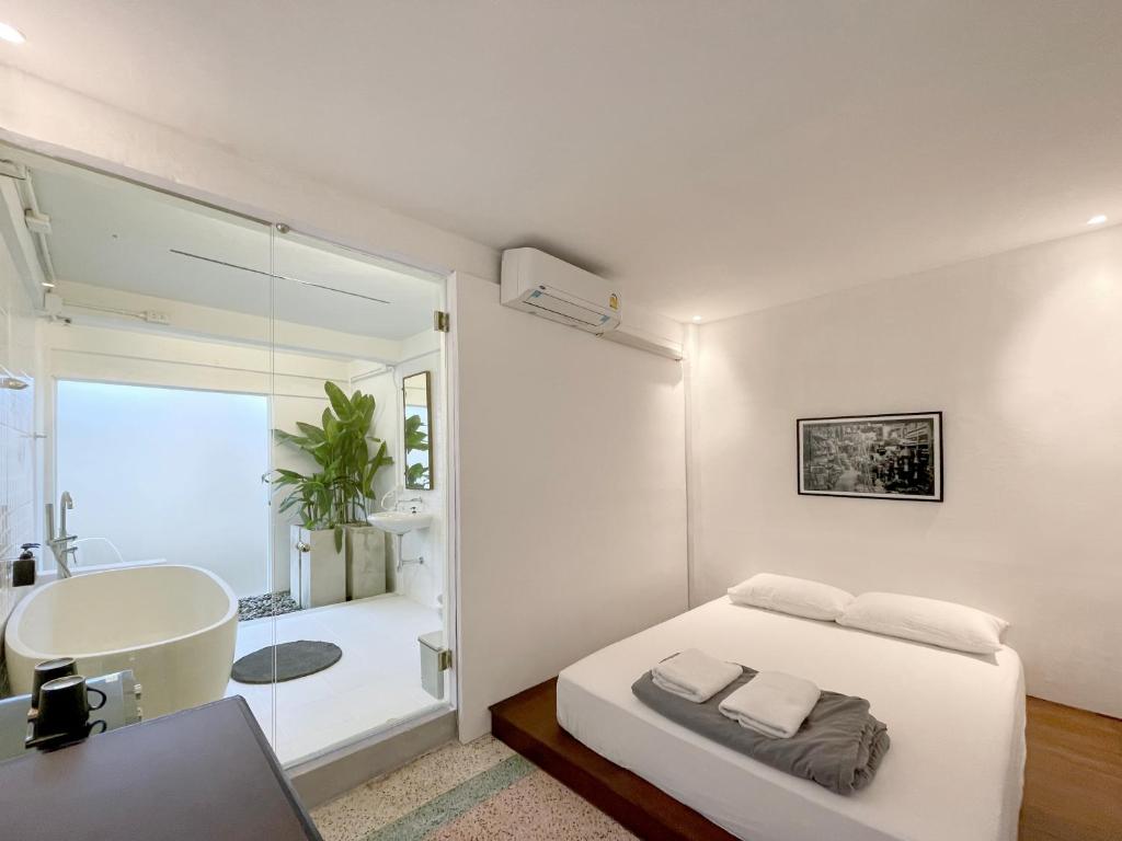 um quarto com uma cama, um lavatório e uma banheira em Chatel BKK em Bang Rak