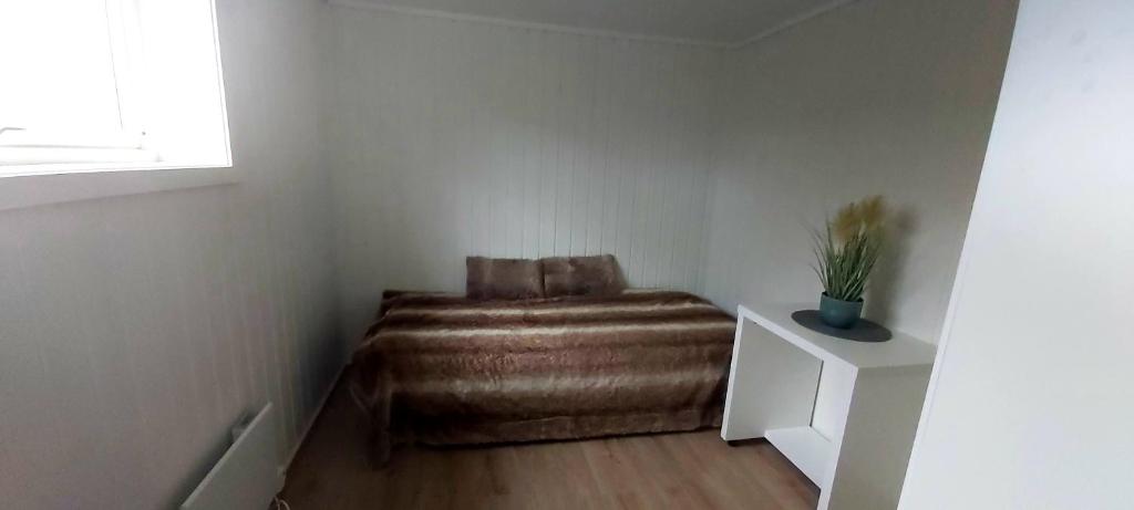 a small room with a brown ottoman in a corner at Aurora rooms for rent nr2 We are doing privet Northen lights trips, reindeer trip and Fjord sommaroy trip in Tromsø