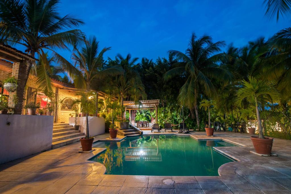a swimming pool in a backyard with palm trees at Casa Sunzal in La Libertad