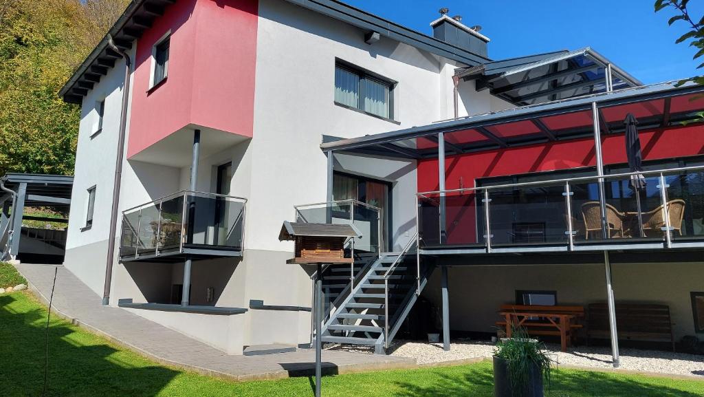 ein Haus mit einer roten und weißen Fassade mit einer Treppe in der Unterkunft Ferienwohnung Goldnugget in Schwarzach im Pongau